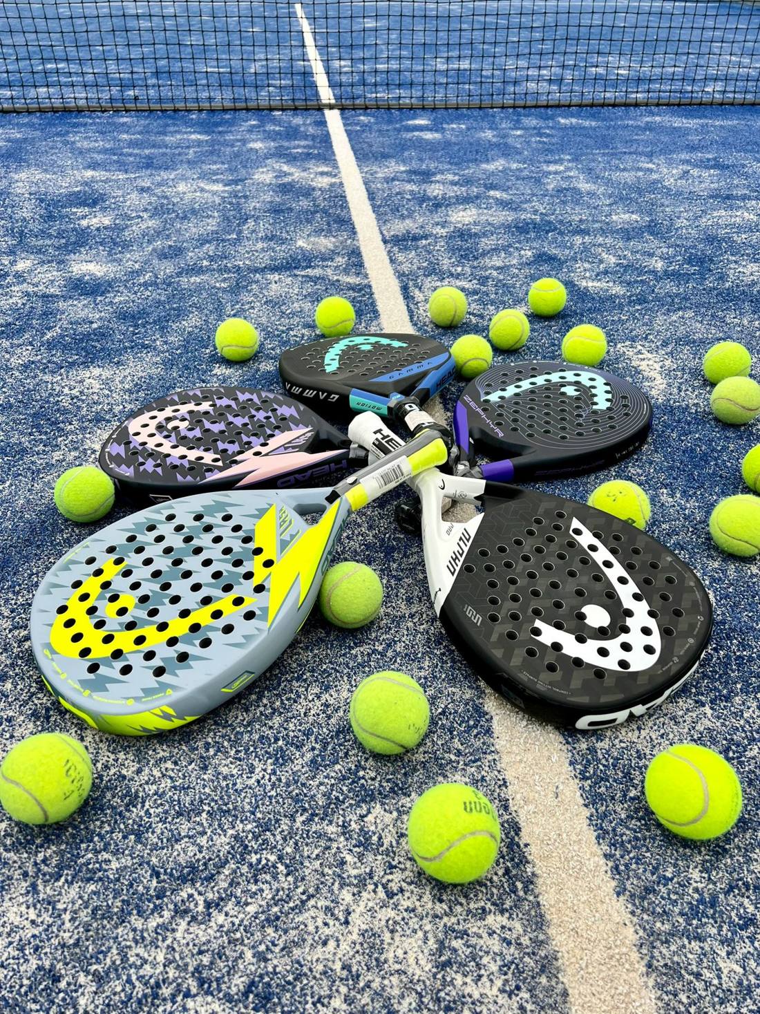 Kind slaat een bal op een overdekte padelbaan